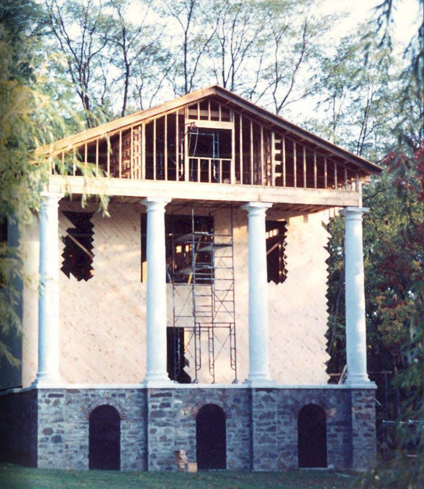 The cladding going on — the house becoming legible as a classical composition